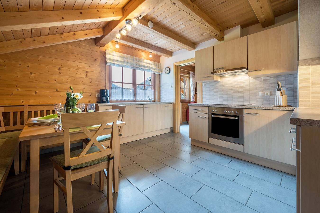 Küche mit Herd, Geschirrspüler und Esstisch in der Ferienwohnung